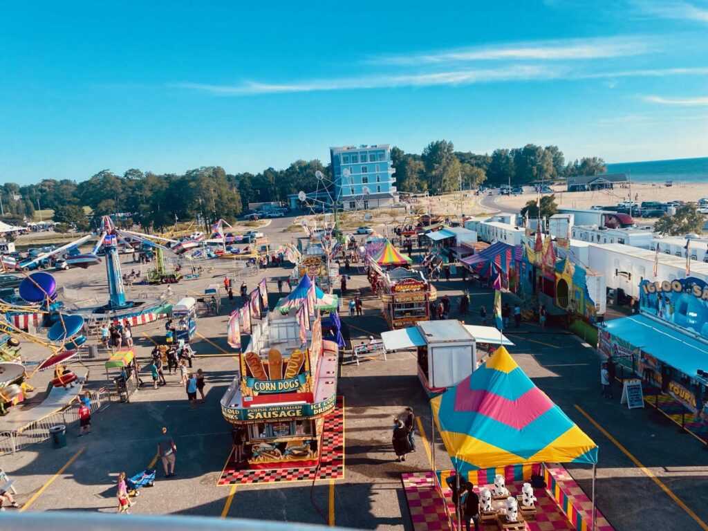 Vibrant fairground with rides and food stalls.