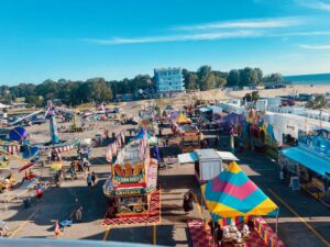 Vibrant fairground with rides and food stalls.