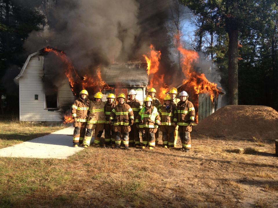Firefighters in front of burning building training drill.