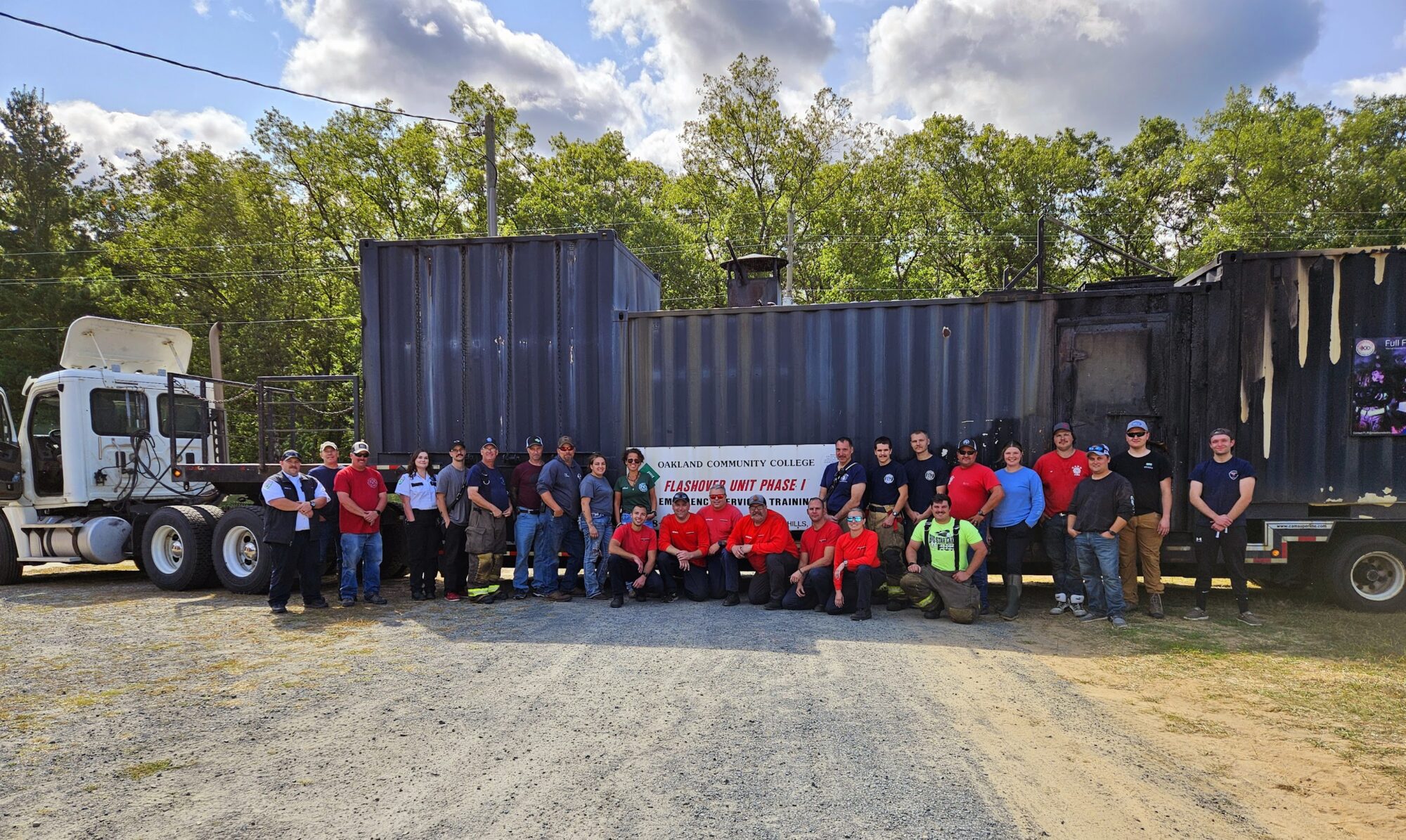 Group posing by training truck at community college.